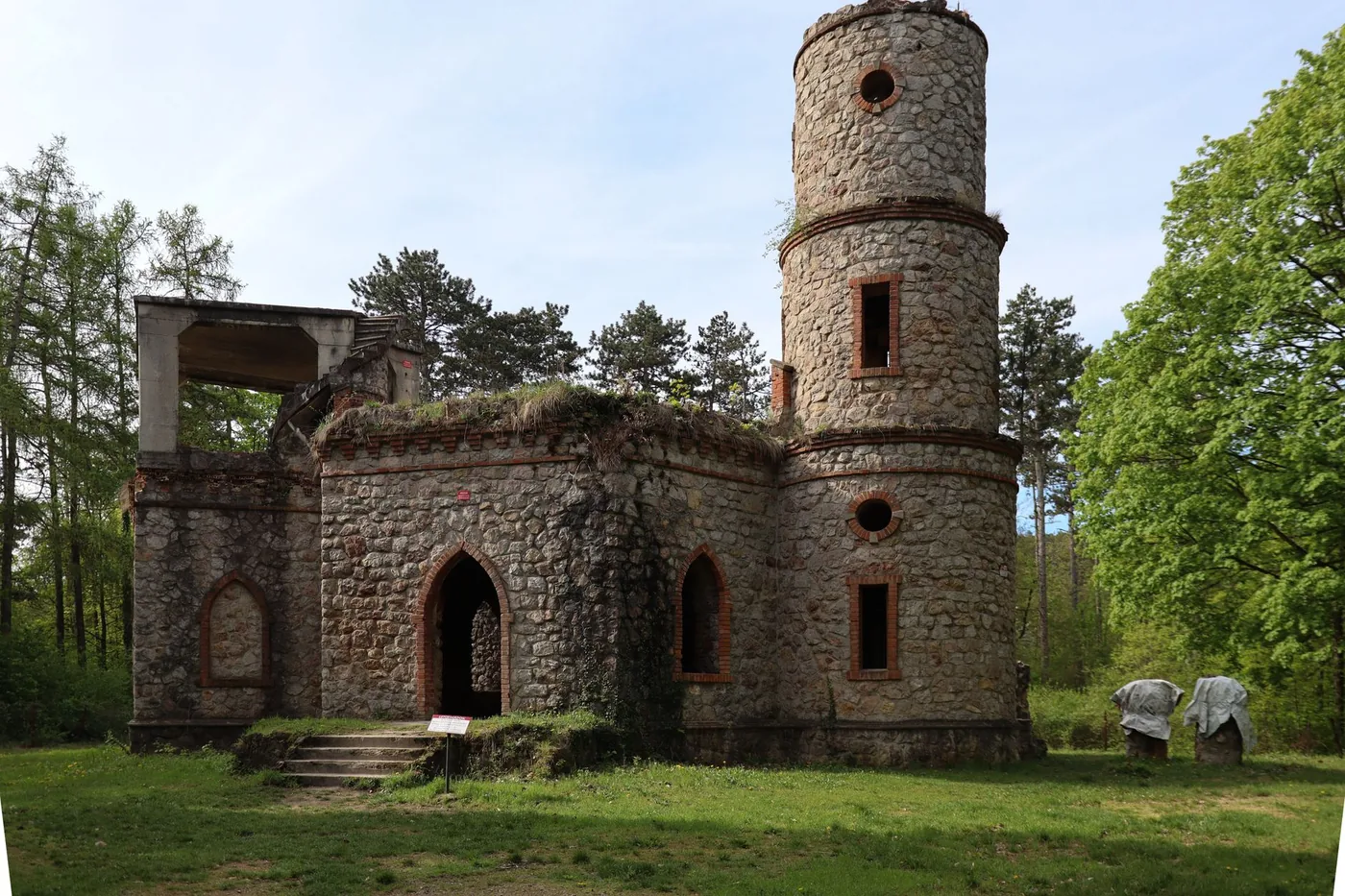 Zřícenina kamenné věže mezi stromy